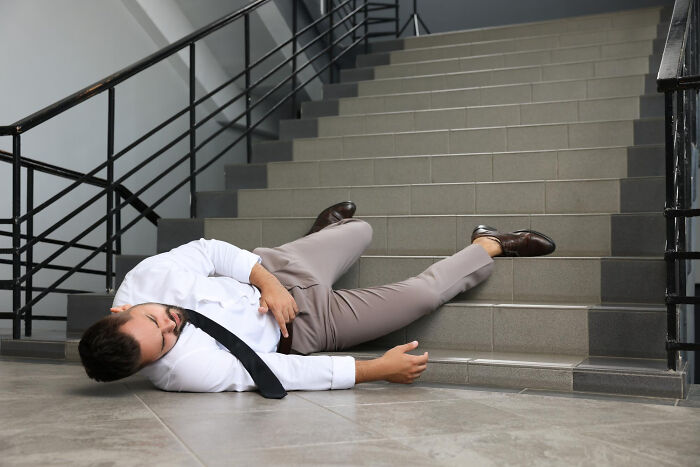 Man lying on floor after falling down stairs, illustrating revenge stories with bitter aftertaste instead of petty victory.