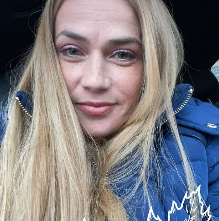 Close-up of a woman with long blonde hair wearing a blue jacket, related to Cinnabon worker's racist tirade against Somali couple.