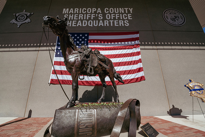 Statue outside Maricopa County Sheriff&rsquo;s Office headquarters with American flag, linked to woman&rsquo;s chilling 911 call case.