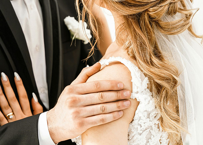 Close-up of a couple embracing at a wedding, illustrating intense moments from people sharing insane ex stories.