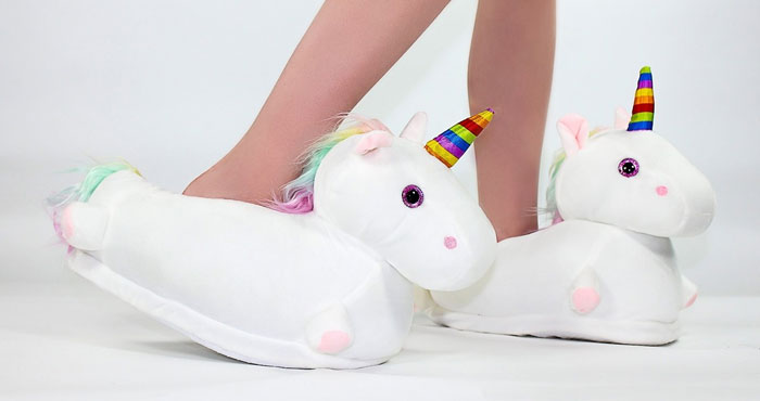 Unicorn white elephant gifts slippers with rainbow horns being worn, perfect for fun and playful gift exchanges.