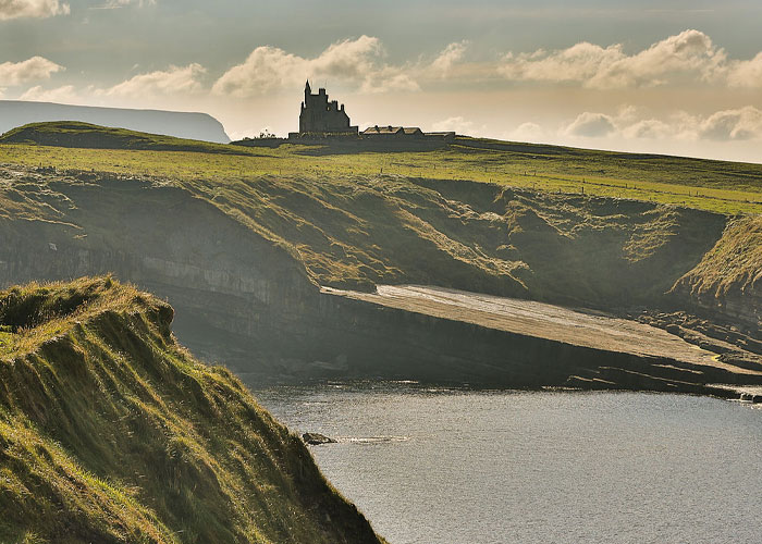 Coastal cliffs with a castle on the horizon, one of the places from around the world that look AI generated but are actually real.