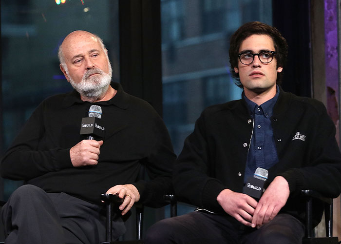 Rob Reiner and his son seated, holding microphones during a discussion about celebrities at Conan O'Brien's party. Rob Reiner and his son seated, holding microphones during a discussion about celebrities at Conan O'Brien's party.