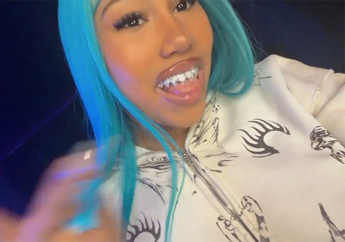 North West, 12, with blue hair and grills, wearing a white patterned hoodie, sparking divided reactions online.