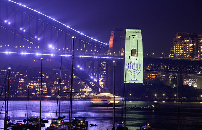 Sydney Harbour Bridge at night with city lights and boats, highlighting public space amid New Year’s Eve controversy. Sydney Harbour Bridge at night with city lights and boats, highlighting public space amid New Year’s Eve controversy.