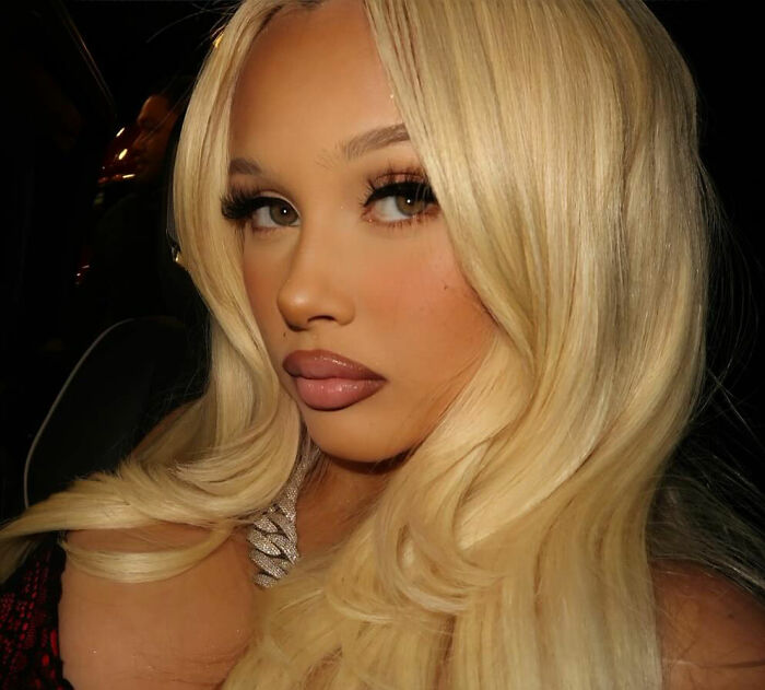 Kourtney Kardashian with long blonde hair and makeup, facing backlash for intimate gift involving Travis Barker's daughter.