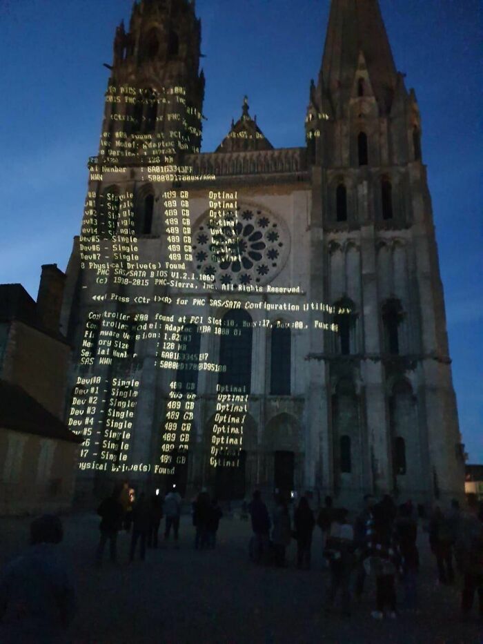 Projection of computer code on a gothic cathedral at night, creating a trippy picture blending technology and architecture.