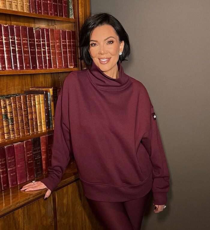 Kris Jenner poses in a burgundy outfit showing hands after viral $100k facelift and ditching gloves in public.