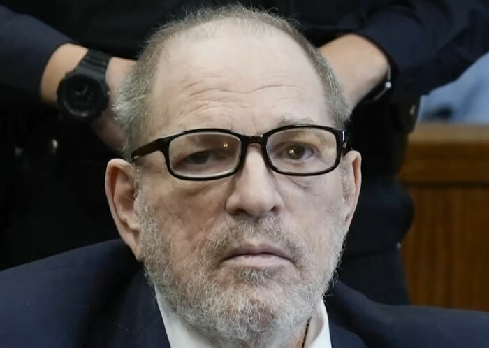 Harvey Weinstein wearing glasses in court, with officers behind him, related to Dame Judi Dench defense outrage. Harvey Weinstein wearing glasses in court, with officers behind him, related to Dame Judi Dench defense outrage.
