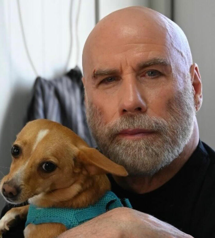 Bald man with beard holding small dog, illustrating bombshell court docs revealing Riley Keough as biological mother of John Travolta&rsquo;s son Ben.