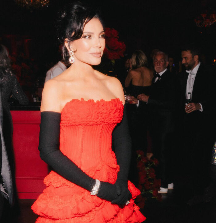 Kris Jenner in a red gown and black gloves at a formal event, highlighting her hands after viral facelift news.
