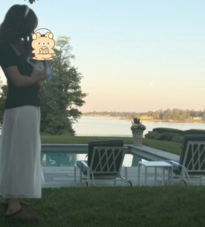 Woman holding newborn by poolside with scenic lake view, related to Millie Bobby Brown newborn daughter viral theory. Woman holding newborn by poolside with scenic lake view, related to Millie Bobby Brown newborn daughter viral theory.