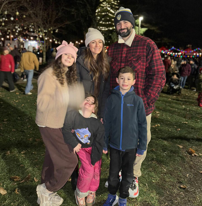 Family posing outdoors at night during Christmas event, related to influencer's daughter passing away tragedy.