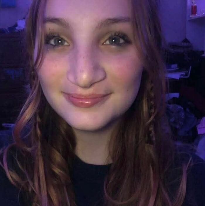 Young woman with long hair smiling softly, highlighting the disturbing tactic accused teens used to lure daughter into woods before attack.