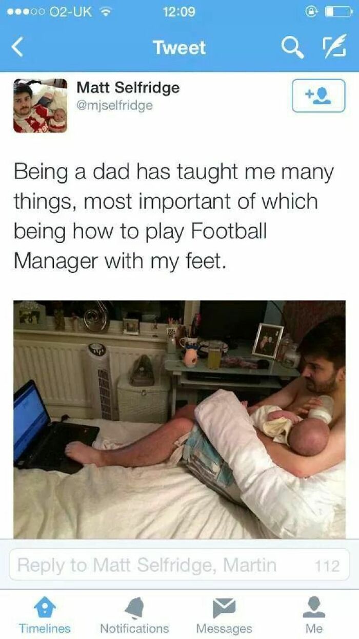 Funny dad multitasking holding baby and playing Football Manager with his feet, capturing cheerful memes about online time.