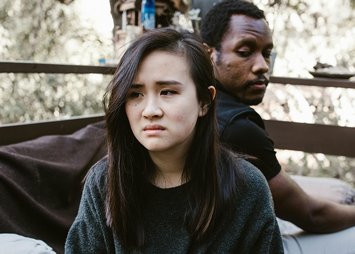 Woman and man sitting apart looking upset, illustrating a toxic mother-in-law causing tension during casual Christmas.