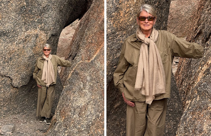 Woman wearing sunglasses and beige scarf stands among large rocks, showing bizarre details in celebrity photos.