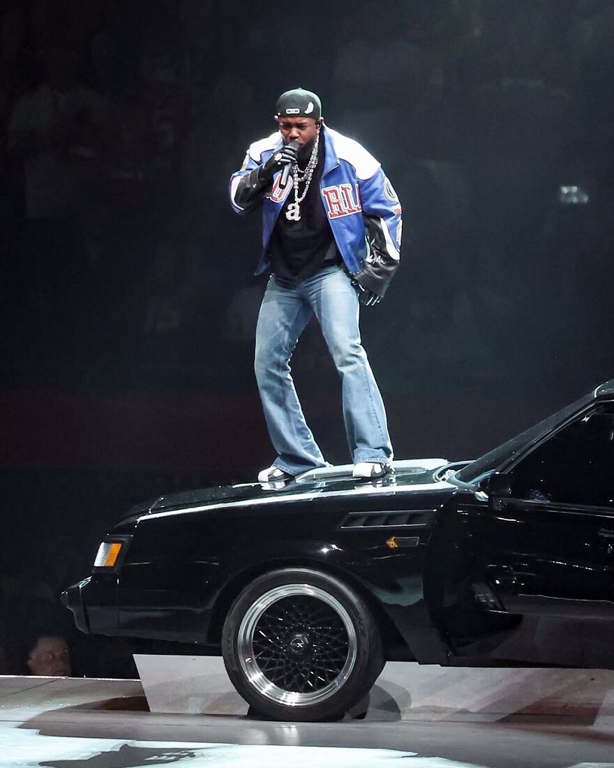 Rapper performing on stage standing on a car during one of the most unforgettable 2025 pop culture moments.