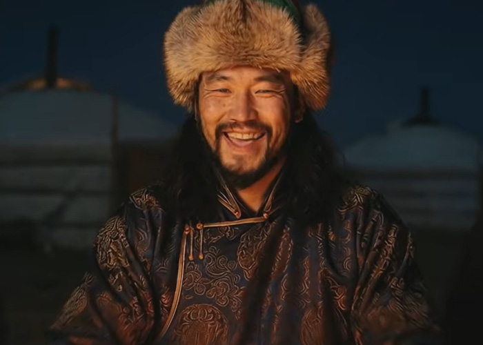 Mongolian man in traditional attire smiling, representing the viral throat singing Christmas anthem for 2025.