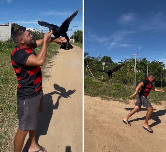 Man wearing a red and black shirt bonding closely with a wild vulture on a sunny dirt path outdoors.