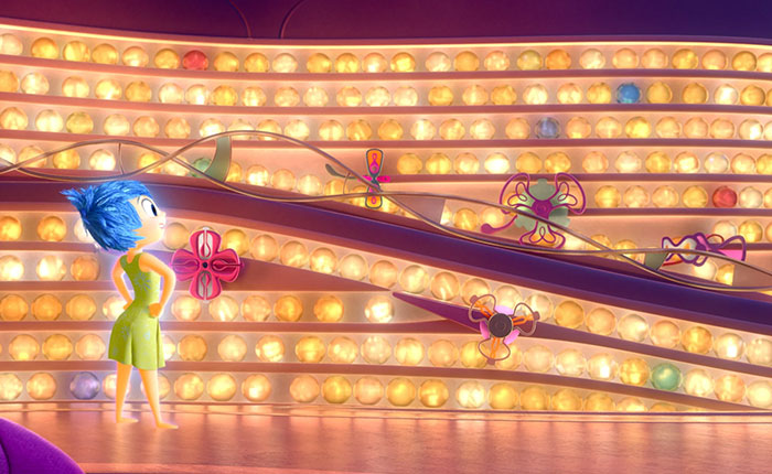 Animated character Joy from Disney Pixar Toy Story inside a colorful light-filled room with mechanical flowers.