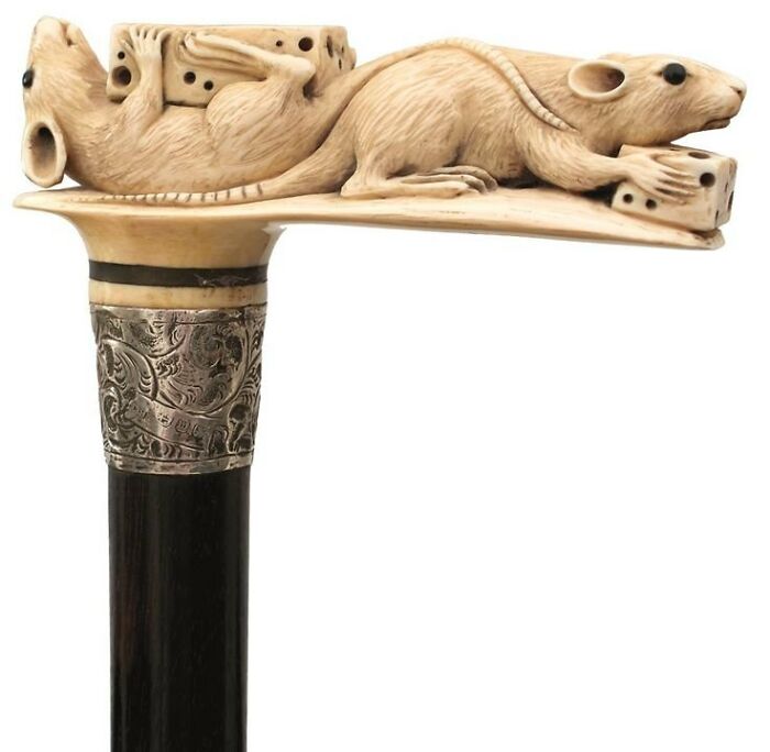 Carved walking cane handle featuring two detailed rats and dice, showcasing culture and everyday life in the past.