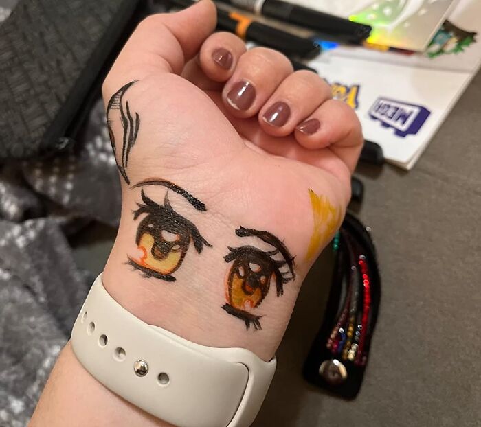 Close-up of a teen's wrist with anime-style eyes drawn in marker, a trending creative gift idea for teens this year.