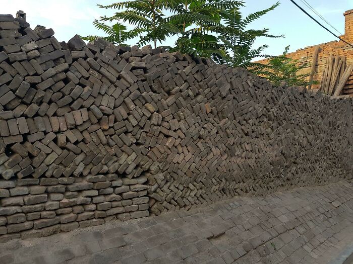 Wall made of bricks stacked unevenly and poorly, showcasing an impressive example of bad job e*******n.