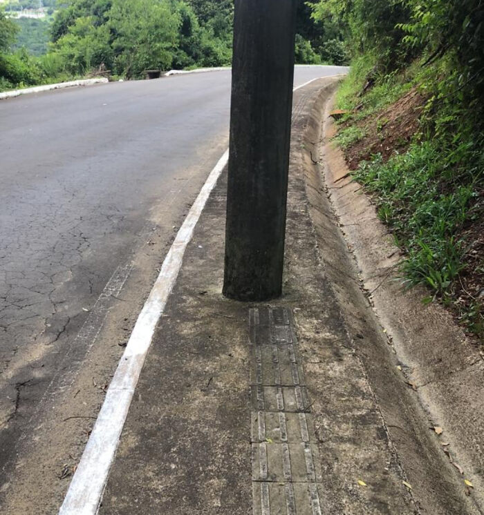Utility pole installed in the middle of a sidewalk, showing poor job e*******n and planning in public infrastructure.