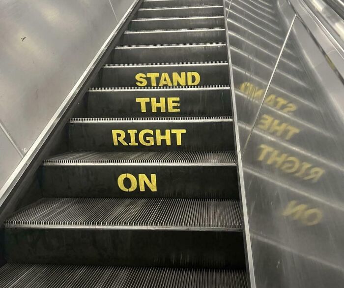 Escalator steps with poorly painted safety instruction saying stand the right on instead of stand on the right