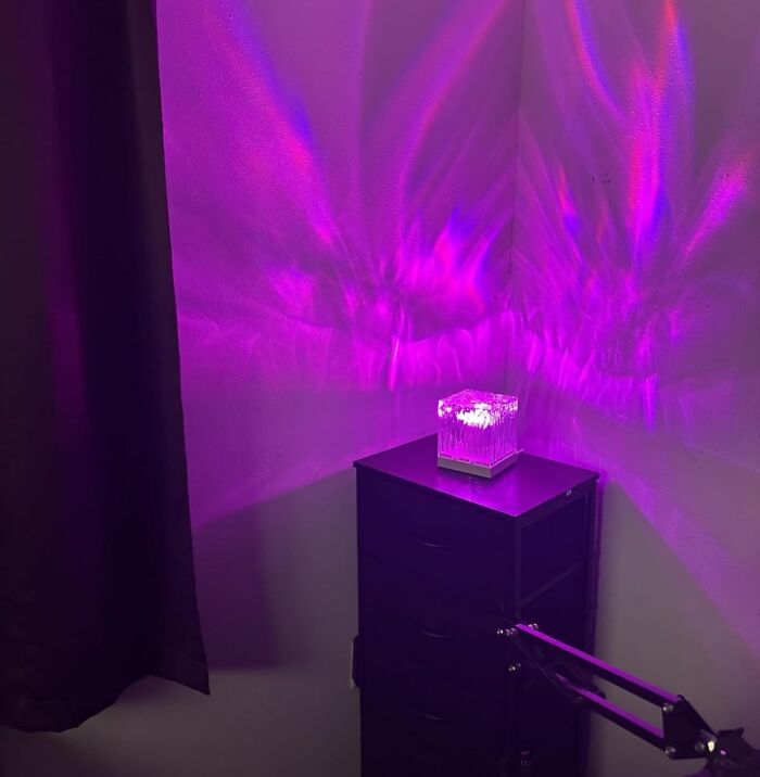 Purple LED night light on a black dresser casting colorful light patterns, a popular product on Amazon wish lists.