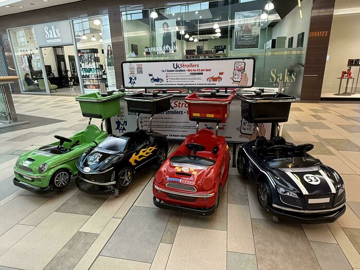Children's motorized strollers lined up in a shopping mall, reflecting the sad and uninspiring dystopia environment.