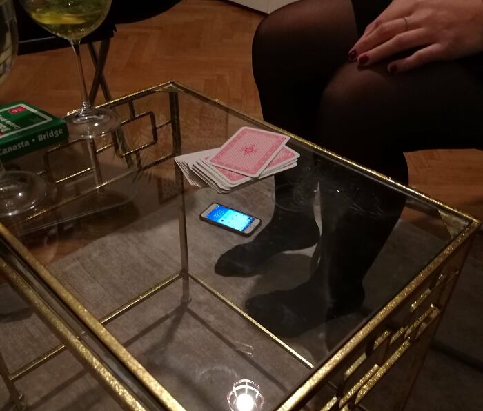 Confusing photo showing a smartphone seemingly under a glass table, playing tricks on the brain to catch up.