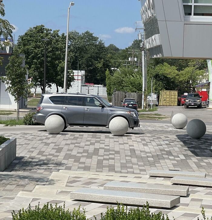SUV parked on spherical concrete blocks instead of wheels, a confusing photo challenging your brain to catch up.