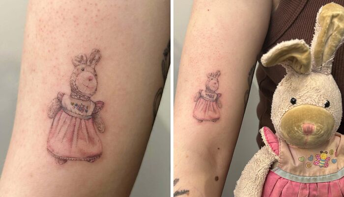 Small wholesome tattoo of a stuffed bunny in a pink dress matching the plush toy, showing meaningful ink design.