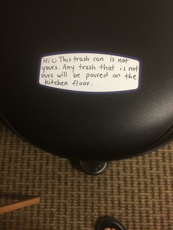 Trash can with a handwritten warning note threatening to pour trash on the kitchen floor, a rage-inducing picture.