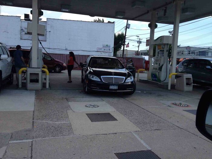 Car blocking multiple gas pumps at a station, showing a frustrating rage-inducing parking situation.
