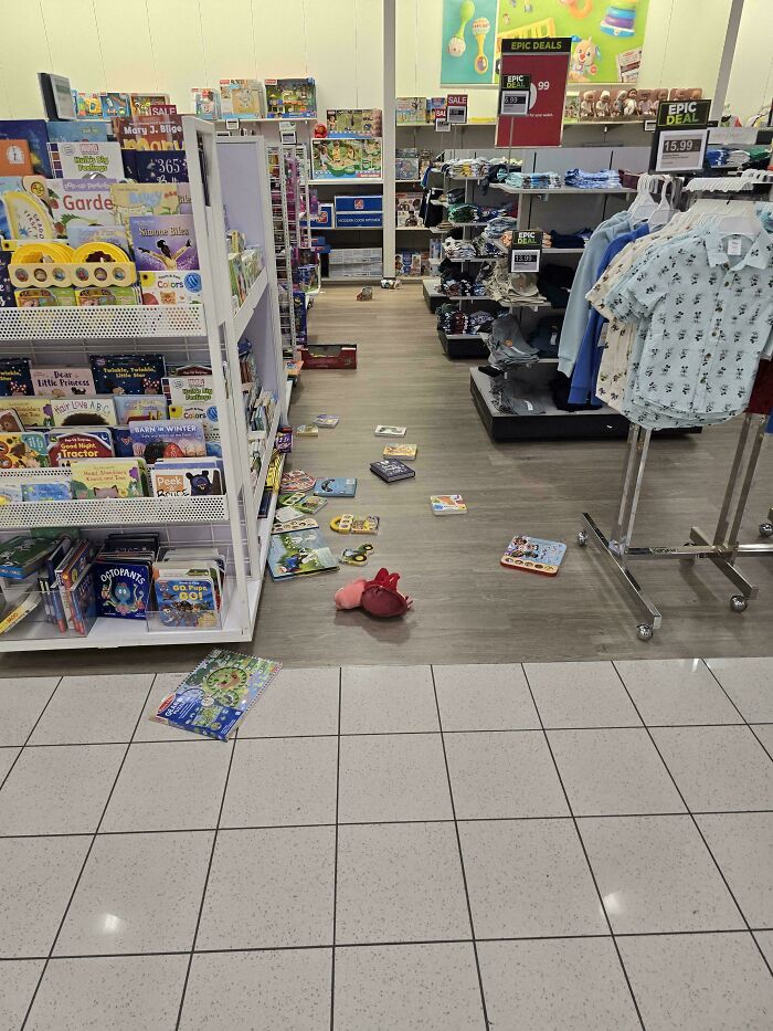 Toys and books scattered on the floor in a store aisle, creating a rage-inducing messy shopping scene.