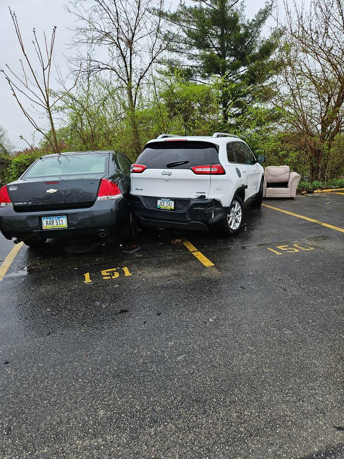 Two cars parked incorrectly, occupying two spaces with a couch left in neighboring parking spot, rage-inducing parking fail.