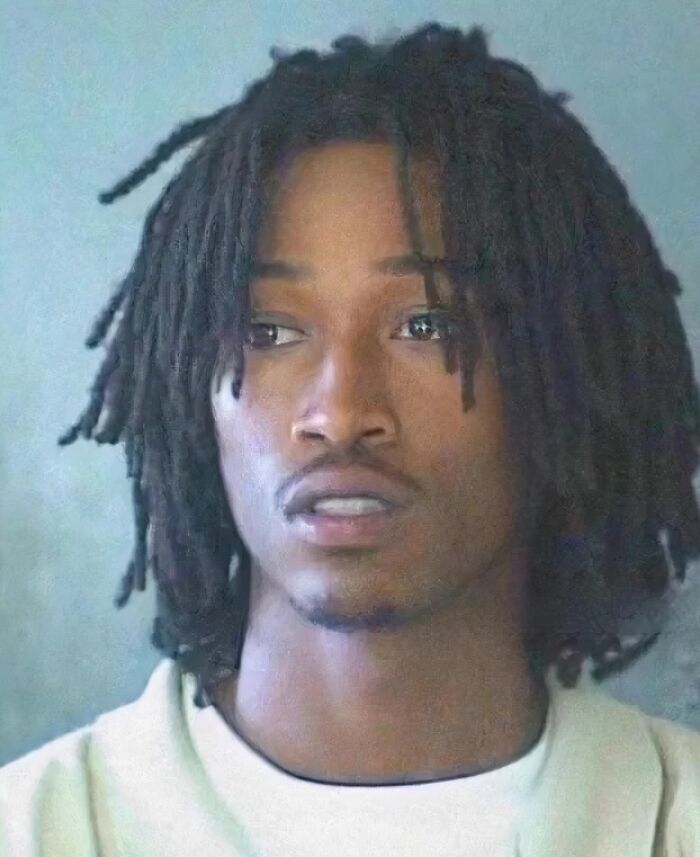Mugshot of a young man with dreadlocks looking to the side after being arrested, featured in celeb mugshot collection.