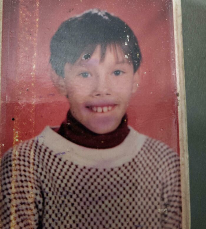 Vintage childhood photo of a smiling boy wearing a patterned sweater, capturing hilariously awkward childhood moments.