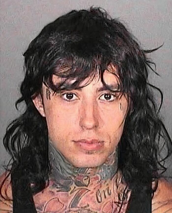 Mugshot of a tattooed male celebrity with long dark hair after being arrested for an unknown offense.