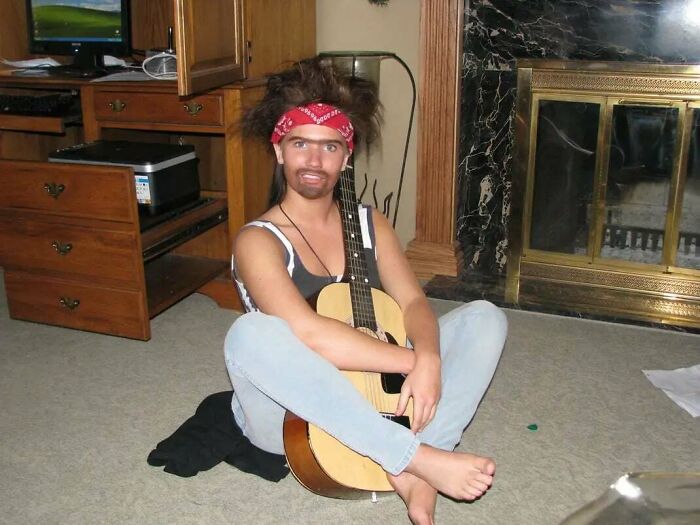 Person in playful costume sitting on carpet holding guitar, a funny and awkward childhood photo with humorous vibe.