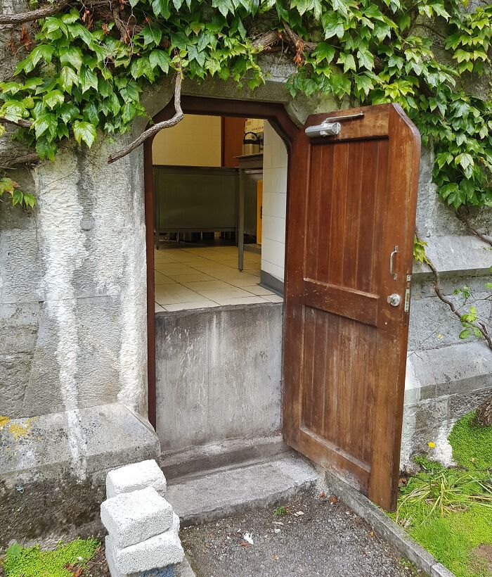 A poorly executed door installation with a large step and blocks outside, showing job done so poorly it’s almost impressive.