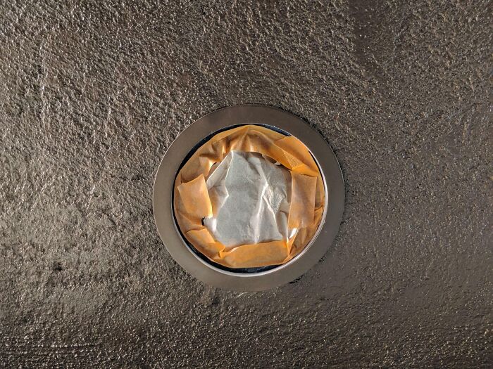 Poorly done job with a sealed ceiling vent covered by wrinkled masking tape and paper, showing careless work.