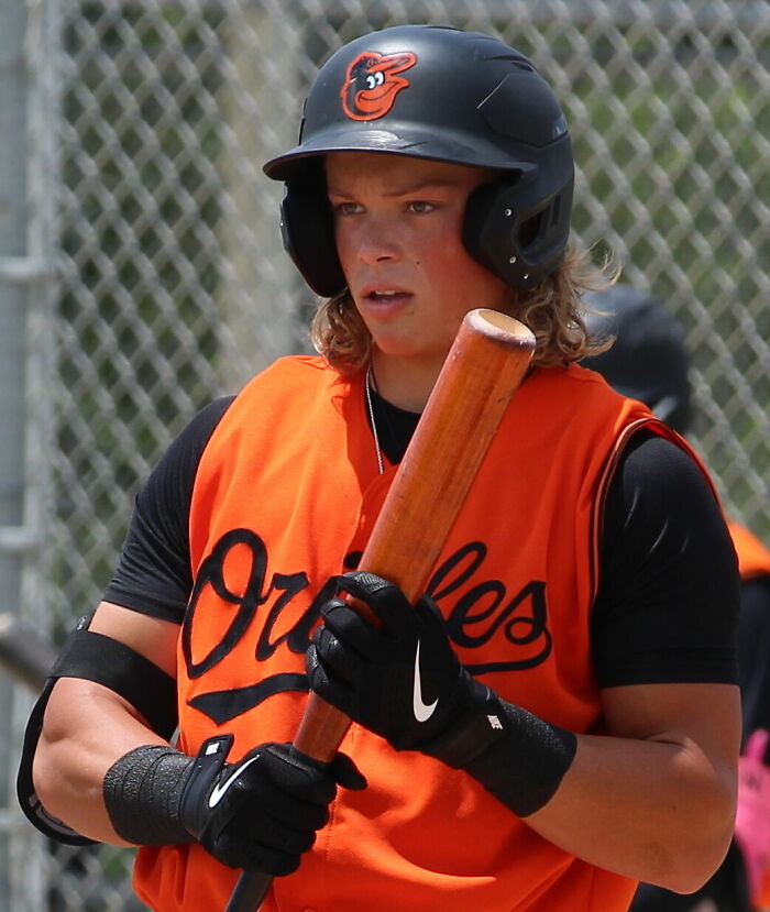 Jackson Holliday wearing Orioles uniform, holding bat, preparing to bat during a baseball game.