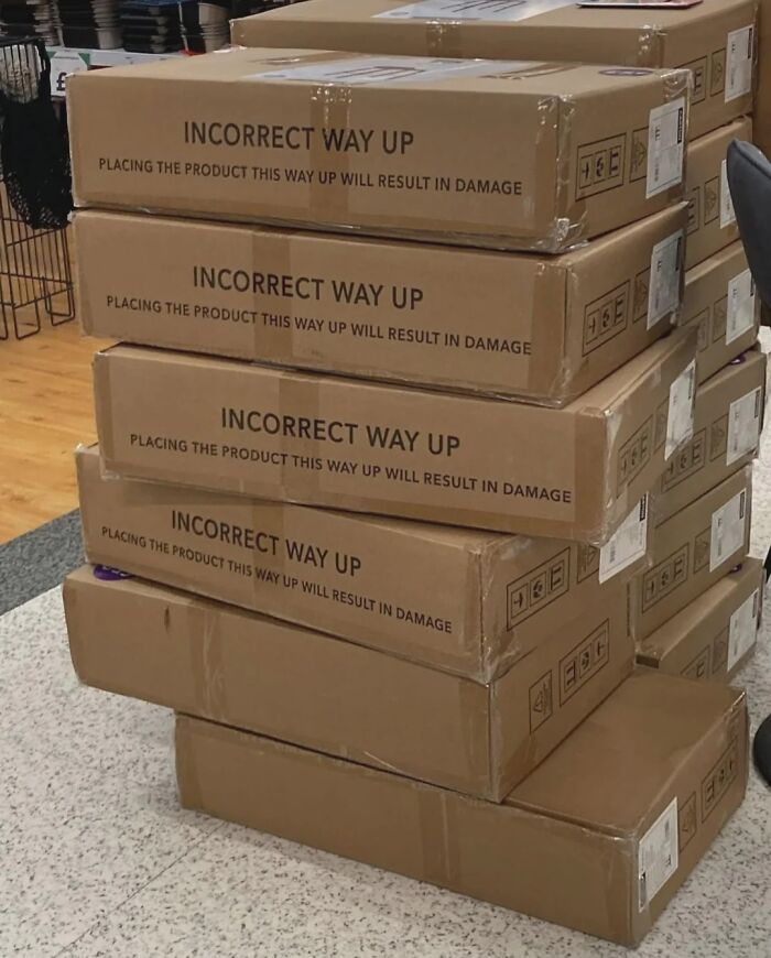 Stack of boxes labeled incorrect way up, demonstrating poor job performance almost impressive in placement and handling.