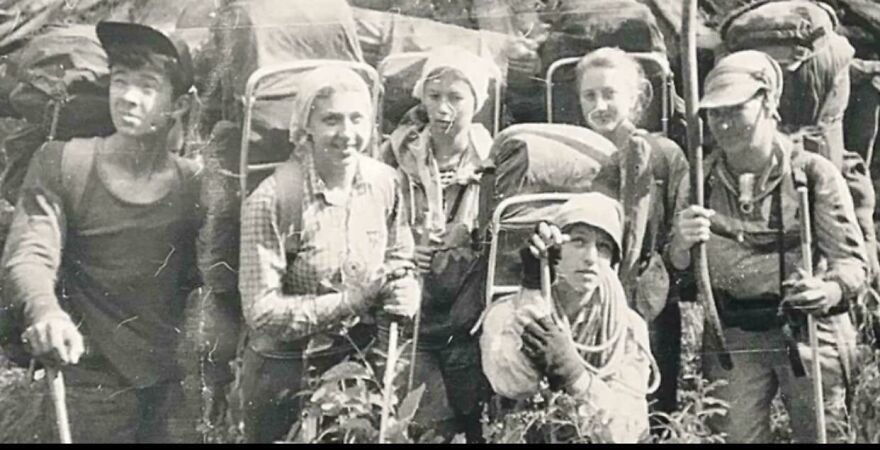 Group of vintage hikers with backpacks and gear posing outdoors in a black and white random pictures image.