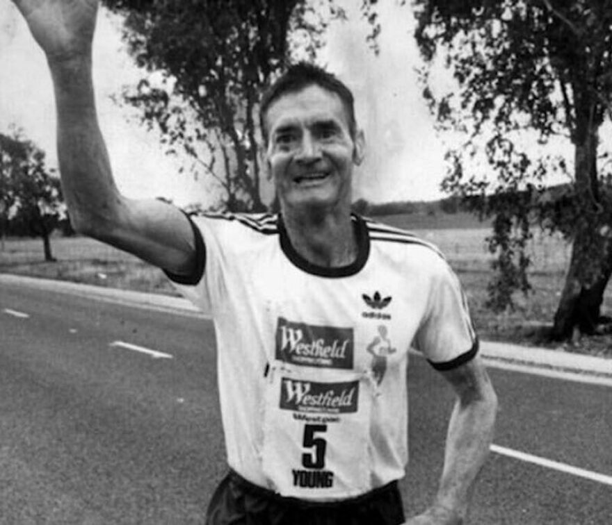 Black and white photo of a man running on road, smiling and waving, illustrating random pictures worth going down a rabbit hole for.