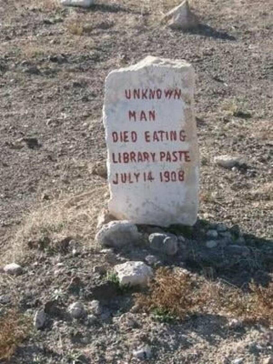 Gravestone of an unknown man who died eating library paste, captured as part of random pictures worth going down a rabbit hole for.